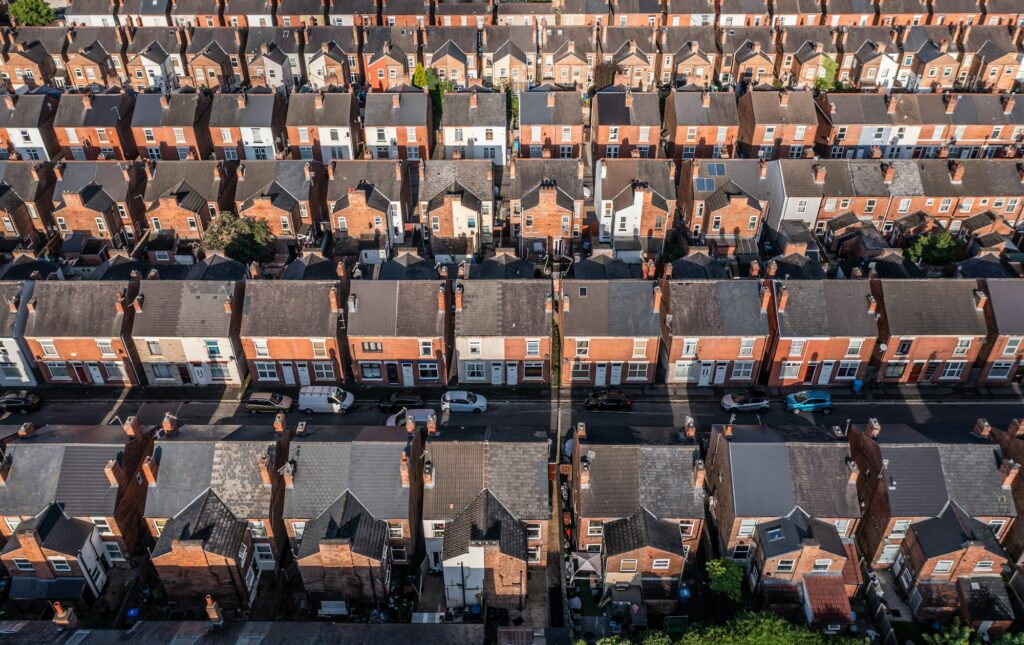 Aerial view above rows of back to back terraced houses on a large council estate